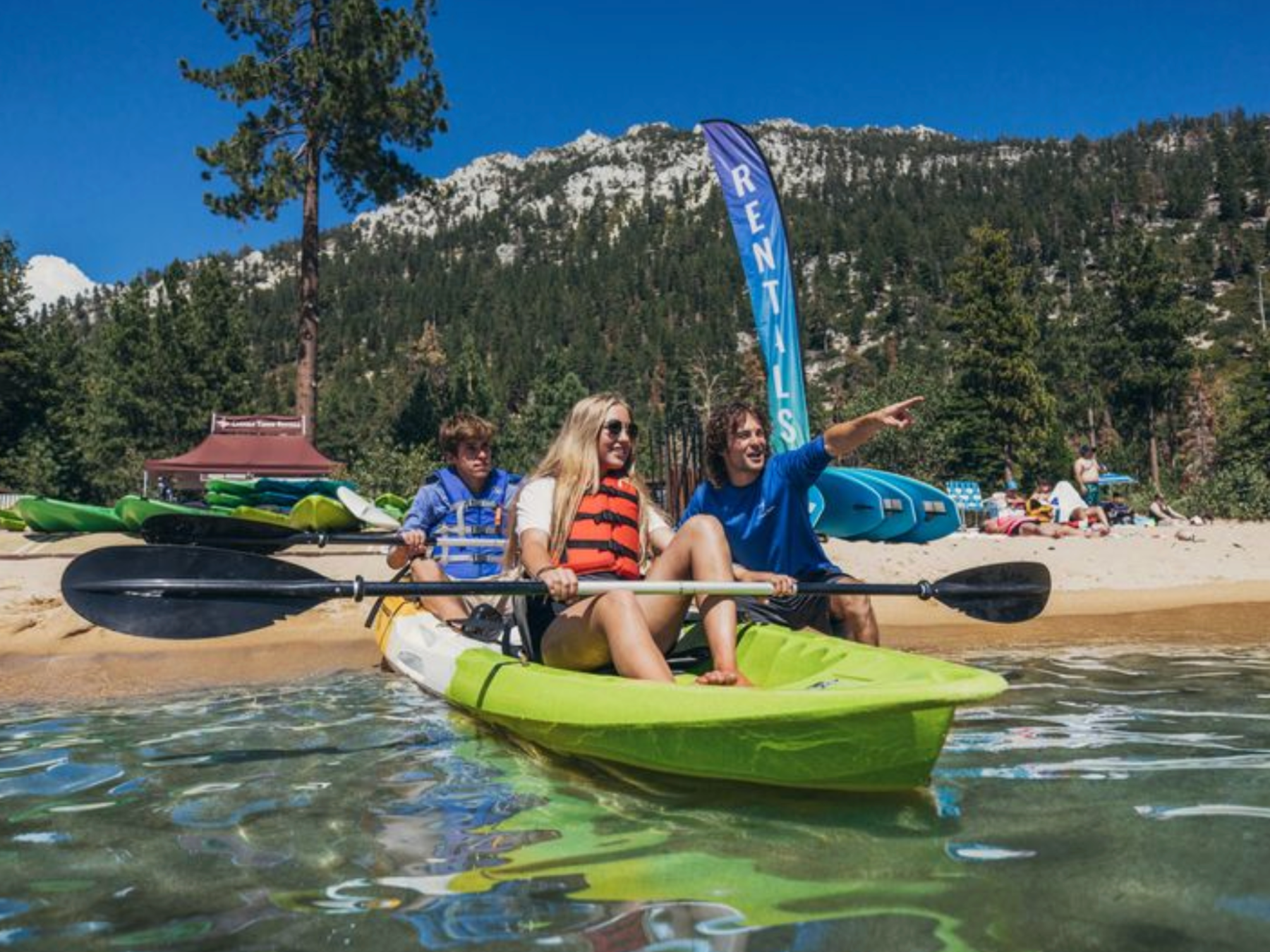 a group of people riding on the back of a boat in the water